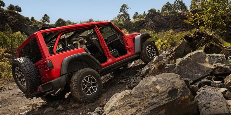 A red 2026 Jeep Wrangler off-raoding.